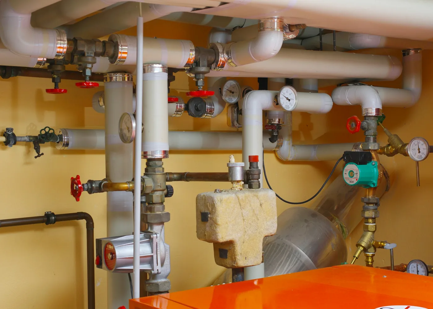Heizungsverteiler mit Manometern, Absperrventilen und Pumpen im Heizraum