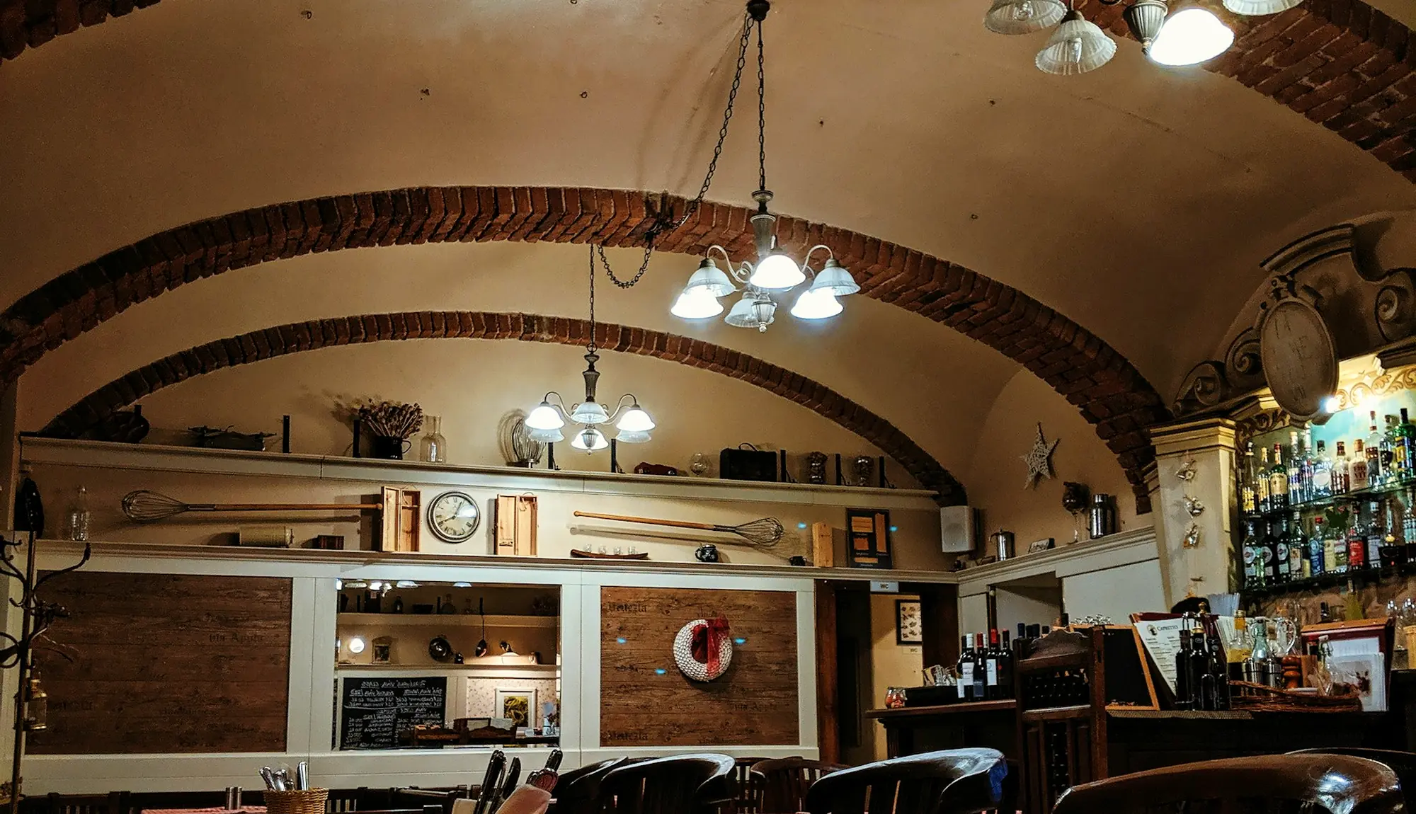 Gewölbter Gastraum der Osteria Marcelli mit Backsteindecke und warmem Licht