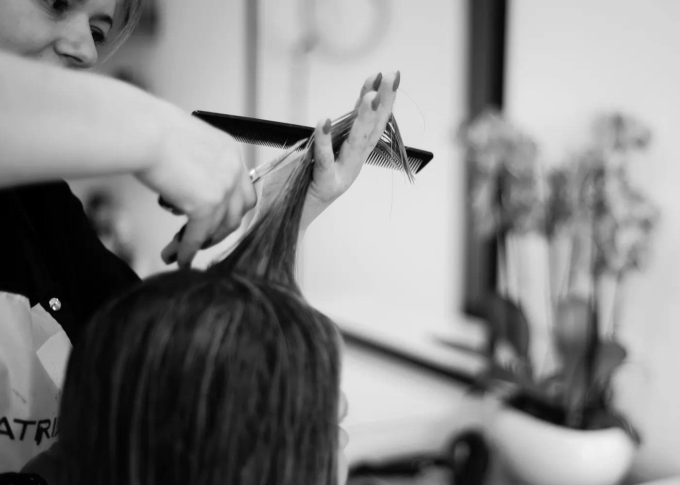Stylistin beim Abteilen einer Haarpartie