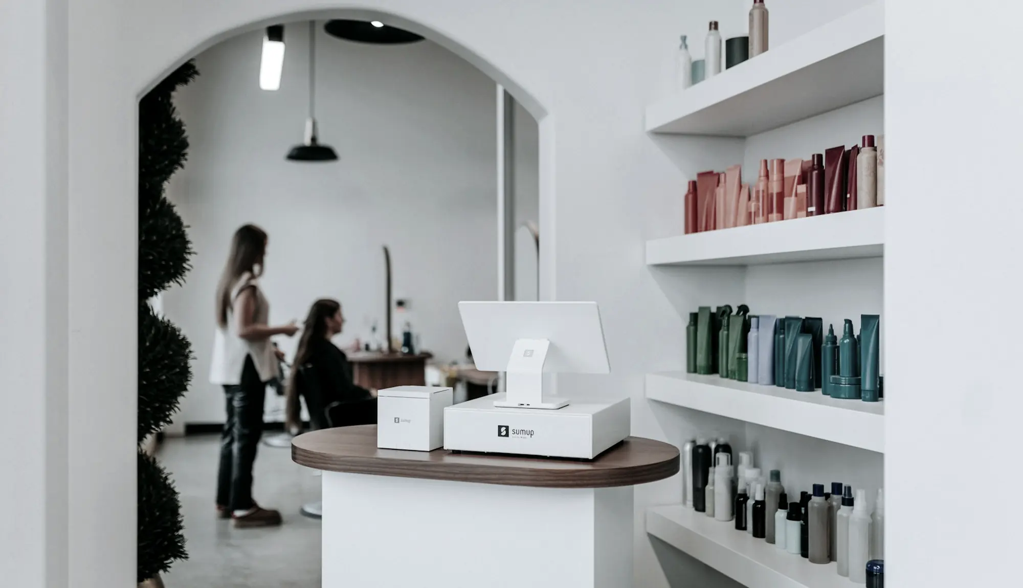 Heller Salonraum mit Rundbogen und Produktregal